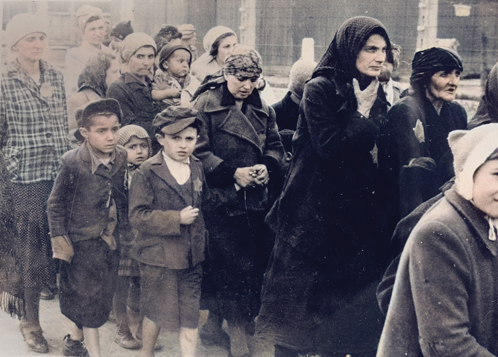 Jewish women and children from Subcarpathian Rus selected by the Nazi SS for death, walk toward the gas chambers of Auschwitz Birkenau German Nazi Concentration and Death Camp (1940-1945). Those pictured include Jolan Wollstein of Szombathely, her children Erwin, Judith, Dori and Naomi, her non-Jewish governess Edith, Henchu Mueller Falkovics, Kreindel Vogel and her sister Sase Vogel and Rita Gruenglass.